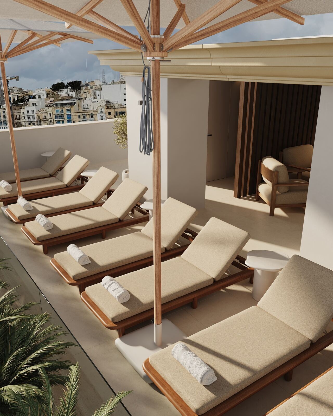 Timber sunbeds and umbrellas beside the rooftop pool